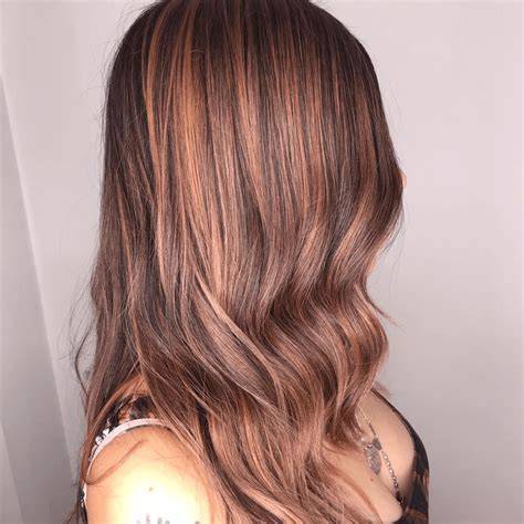 reflejos caoba y caramelo sobre cabello negro